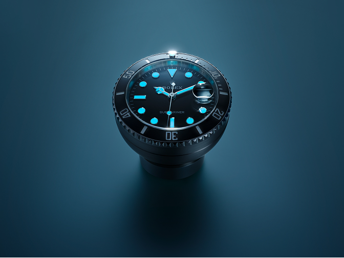 Die Rolex Submariner Date Tischuhr im Dunkeln mit blau leuchtender Chromalight-Anzeige