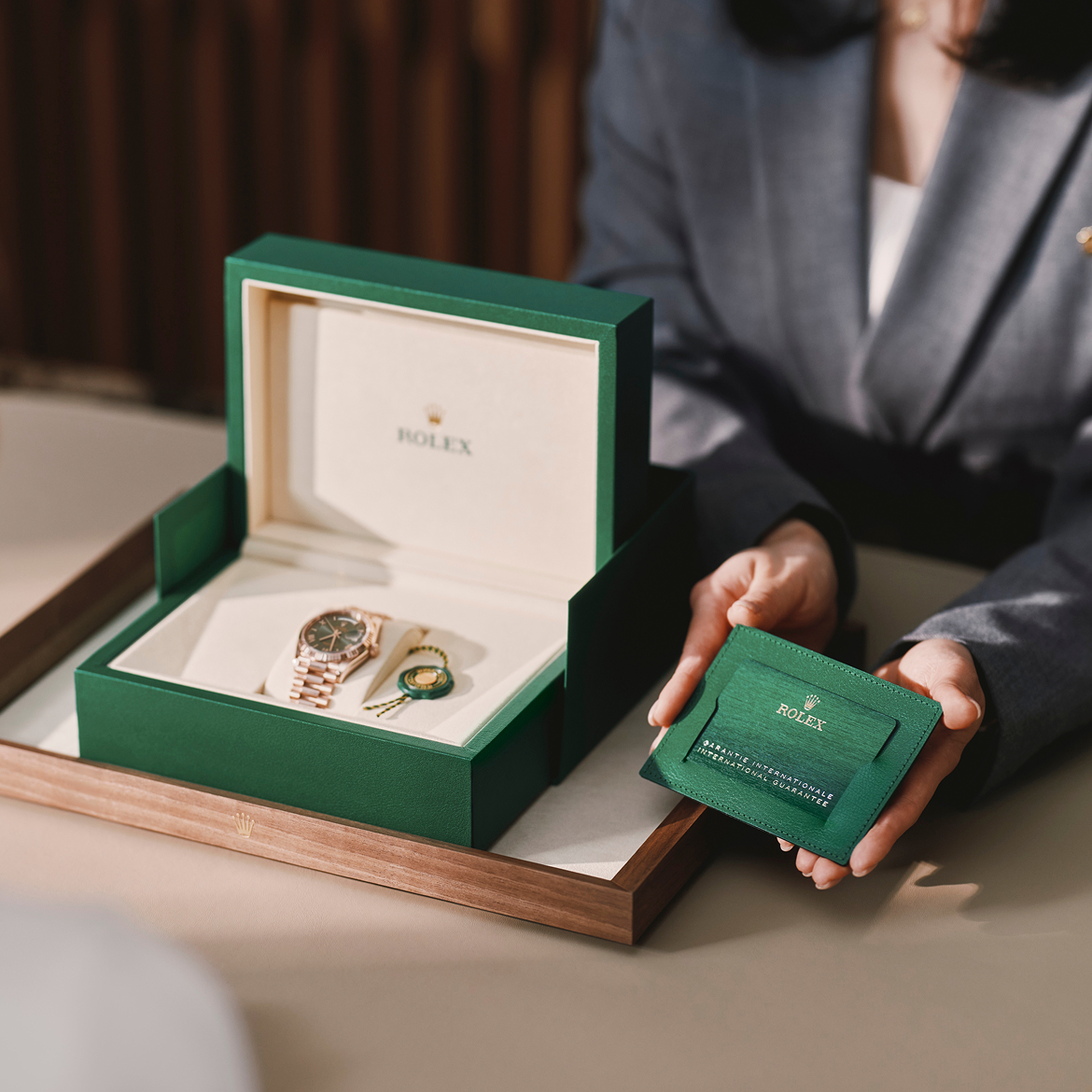 Eine Beraterin überreicht eine Rolex Armbanduhr im Etui