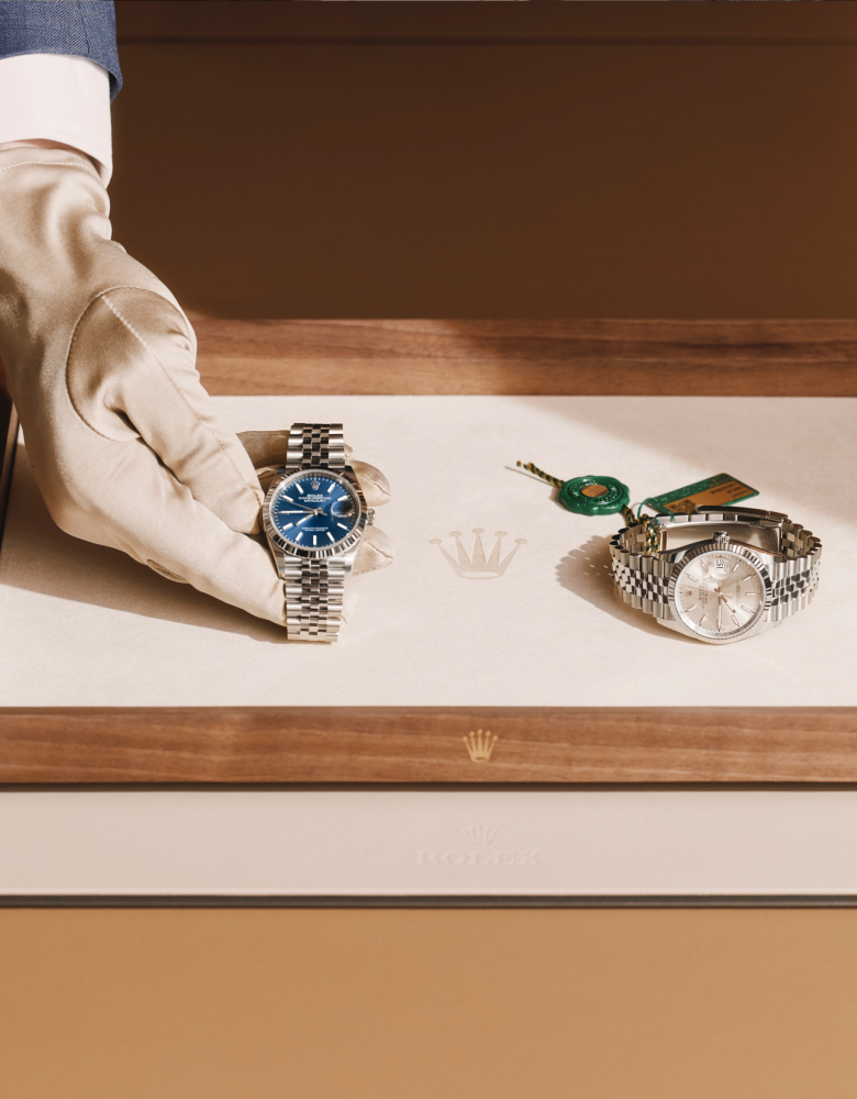 Zwei Rolex Armbanduhren auf einem Präsentationstablett aus Holz